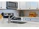 Stylish kitchen featuring stainless steel appliances, white cabinetry, and a mosaic tile backsplash at 2658 S Xanadu Way # B, Aurora, CO 80014