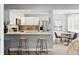 Bright kitchen with white cabinetry, stainless appliances, quartz counters, and eat-in breakfast bar at 2658 S Xanadu Way # B, Aurora, CO 80014