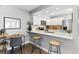 Updated kitchen boasts white cabinets, stainless appliances, quartz countertops, and breakfast bar with seating at 2658 S Xanadu Way # B, Aurora, CO 80014