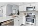 Modern kitchen featuring white cabinets, stainless appliances, quartz counters, and tile backsplash at 2658 S Xanadu Way # B, Aurora, CO 80014