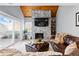 Cozy living room featuring a stone fireplace, wood ceiling, leather furniture, and sliding door access to the outside at 2658 S Xanadu Way # B, Aurora, CO 80014
