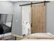 Bedroom featuring a bathroom with a sliding barn door at 2658 S Xanadu Way # B, Aurora, CO 80014
