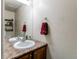 Bathroom features a wood vanity with a sink, granite countertop, and a decorative mirror and towel rack at 535 Lost Valley Pt, Castle Rock, CO 80108