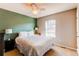 Bright bedroom features a large window, green accent wall, ceiling fan, and a bed with decorative lamps at 535 Lost Valley Pt, Castle Rock, CO 80108