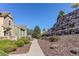 Exterior view of townhomes, showcasing a landscaped walkway and terraced stone retaining wall at 535 Lost Valley Pt, Castle Rock, CO 80108