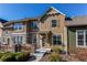 Charming two-story townhouse featuring a stone porch, wood siding, and manicured landscaping at 535 Lost Valley Pt, Castle Rock, CO 80108