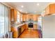 Bright kitchen with stainless steel appliances and natural wood cabinets with tiled backsplash at 535 Lost Valley Pt, Castle Rock, CO 80108