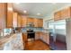 Well-lit kitchen features stainless steel appliances, sleek countertops, and maple wood cabinetry at 535 Lost Valley Pt, Castle Rock, CO 80108