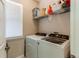 Bright laundry room features modern washer and dryer, plus shelving for storage and a window for natural light at 535 Lost Valley Pt, Castle Rock, CO 80108