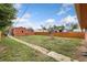 Wide backyard with a full fence, a brick pathway, and a mix of sparse grass at 544 S 3Rd Ave, Brighton, CO 80601