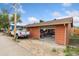 A garage with a partially opened door and a white pickup truck parked outside at 544 S 3Rd Ave, Brighton, CO 80601