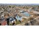 Neighborhood aerial view with blue house, solar panels, wood fence, and street parking at 717 Walden Ct, Highlands Ranch, CO 80126