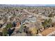 An aerial view of a neighborhood with mature trees, blue-sided houses and mountain views at 717 Walden Ct, Highlands Ranch, CO 80126