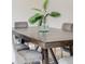 Close-up of dining table featuring stylish, dark wood, decorative plant, and comfortable gray chairs at 717 Walden Ct, Highlands Ranch, CO 80126