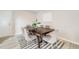 Bright dining room features a dark wood table with gray upholstered chairs and a striped rug at 717 Walden Ct, Highlands Ranch, CO 80126