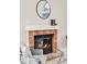 Close-up of the brick fireplace with a decorative mantel and a round mirror above at 717 Walden Ct, Highlands Ranch, CO 80126