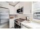 Bright kitchen features stainless steel appliances, white cabinets, and light countertop at 717 Walden Ct, Highlands Ranch, CO 80126