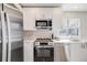 Bright kitchen features stainless steel appliances, white cabinets, and light countertop at 717 Walden Ct, Highlands Ranch, CO 80126