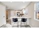 Open kitchen with stainless steel appliances, white cabinets, and seating at 717 Walden Ct, Highlands Ranch, CO 80126