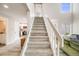 Bright foyer with a carpeted staircase, views of the kitchen and living area at 717 Walden Ct, Highlands Ranch, CO 80126