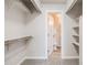 Spacious walk-in closet leading to a toilet offering ample storage with built-in shelves and rods at 717 Walden Ct, Highlands Ranch, CO 80126