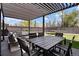 A backyard with a covered patio featuring an outdoor dining set and lounge area for relaxing and entertaining at 4895 E Arizona Ave, Denver, CO 80246
