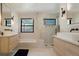 Bright bathroom featuring double vanities, black fixtures, and a spacious glass enclosed shower with a soaking tub at 4895 E Arizona Ave, Denver, CO 80246