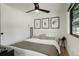 Modern bedroom with ceiling fan, window, and decorative celestial artwork at 4895 E Arizona Ave, Denver, CO 80246