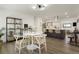 Bright dining area with a modern round table and open view to the stylish kitchen with a large island at 4895 E Arizona Ave, Denver, CO 80246
