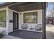 A charming front porch featuring modern chairs and a small table for relaxing and enjoying the outdoors at 4895 E Arizona Ave, Denver, CO 80246