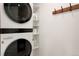 Organized laundry area with stacked washer/dryer and shelving for storage at 4895 E Arizona Ave, Denver, CO 80246