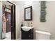 Bathroom includes a dark vanity, sink, mirror, and modern decorative accent on the wall at 2434 S Ogden St # 2434-2436, Denver, CO 80210