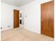 A bedroom with neutral carpet and walls shows two doors and an open view to another room at 2434 S Ogden St # 2434-2436, Denver, CO 80210