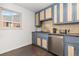 A cozy kitchen with blue cabinets, stainless steel appliances, and a stylish tile backsplash at 2434 S Ogden St # 2434-2436, Denver, CO 80210
