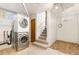 Basement laundry room features stacked washer/dryer, access to the stairs, and a window at 2434 S Ogden St # 2434-2436, Denver, CO 80210