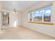 Living room with a large window and a view; neutral walls, and carpet flooring at 2434 S Ogden St # 2434-2436, Denver, CO 80210