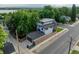 A modern home with a detached garage features a fenced yard, surrounded by mature trees on a corner lot at 2540 Xavier St, Denver, CO 80212