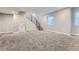 Finished basement featuring modern staircase, natural light, and neutral color palette at 2540 Xavier St, Denver, CO 80212