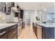 Bright kitchen featuring stainless steel appliances, dark cabinets, and a view into the pantry at 2540 Xavier St, Denver, CO 80212