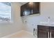 Functional laundry room featuring modern cabinetry, a sink, and washer/dryer hookups at 2540 Xavier St, Denver, CO 80212