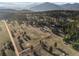 Scenic aerial shot of a property, featuring vast open fields, mountain views, and a winding access road at 33379 Buffalo Park Rd, Evergreen, CO 80439