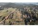 Captivating aerial perspective of a home set amidst a lush, green landscape and rolling hills in a mountain setting at 33379 Buffalo Park Rd, Evergreen, CO 80439
