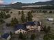 Expansive aerial shot of a sprawling estate nestled in a mountain valley with gorgeous mountain views at 33379 Buffalo Park Rd, Evergreen, CO 80439