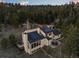 Aerial view of home featuring solar panels, a patio, and a surrounding wooded area at 33379 Buffalo Park Rd, Evergreen, CO 80439