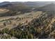Expansive aerial view of a secluded home nestled among trees and open fields, offering privacy at 33379 Buffalo Park Rd, Evergreen, CO 80439