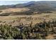 Aerial view of a house with a mountain and forest landscape at 33379 Buffalo Park Rd, Evergreen, CO 80439