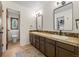 Bathroom featuring double sinks, dark brown cabinets, and an opening to the toilet and shower area at 33379 Buffalo Park Rd, Evergreen, CO 80439