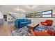 Living room featuring a blue velvet couch, bright orange chairs, and a black staircase at 33379 Buffalo Park Rd, Evergreen, CO 80439