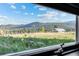 View of green fields and mountains seen through a window at 33379 Buffalo Park Rd, Evergreen, CO 80439
