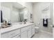 Bathroom featuring double vanity, large mirror, a tub with shower, and a window at 12941 Delaware St, Westminster, CO 80234